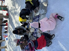 Mme Erinn creating bird feeders with Kindergarten students.